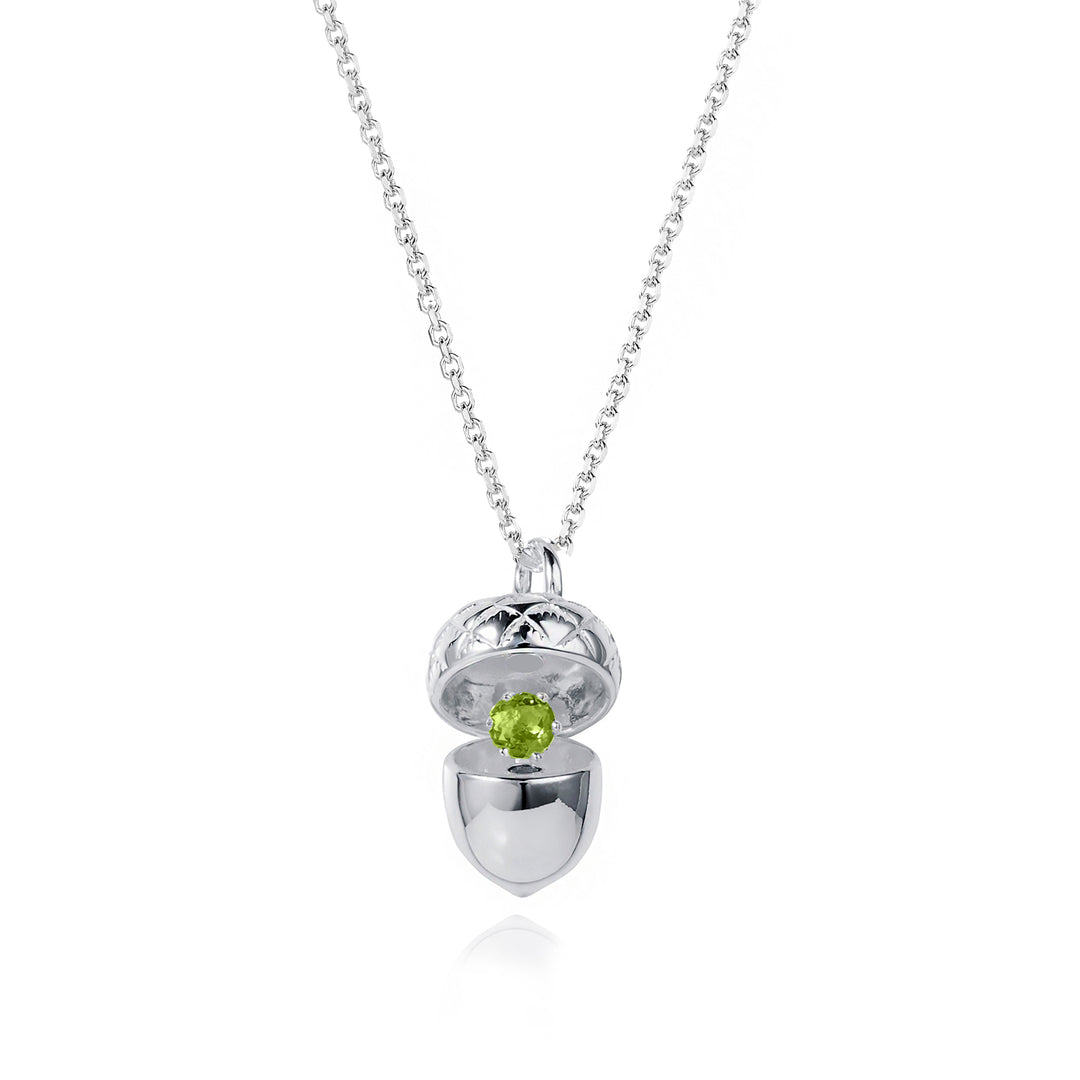 Silver acorn locket opened up to show a peridot august birthstone on a white background