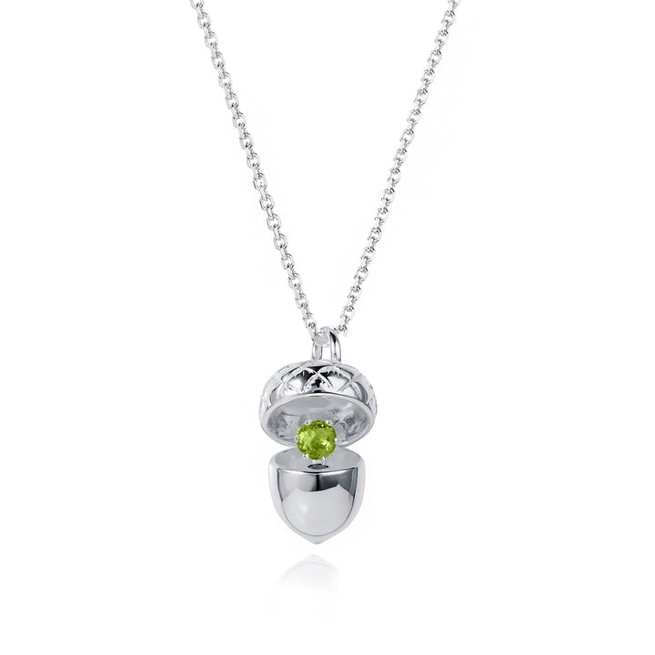 Silver acorn locket opened up to show a peridot august birthstone on a white background