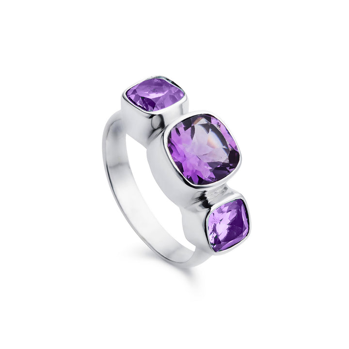 Amethyst three stone ring in silver against a white background