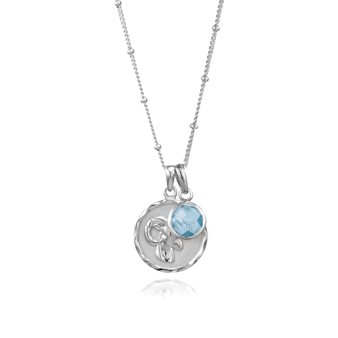Silver Aries zodiac pendant and chain with blue topaz  march birthstone charm on white background