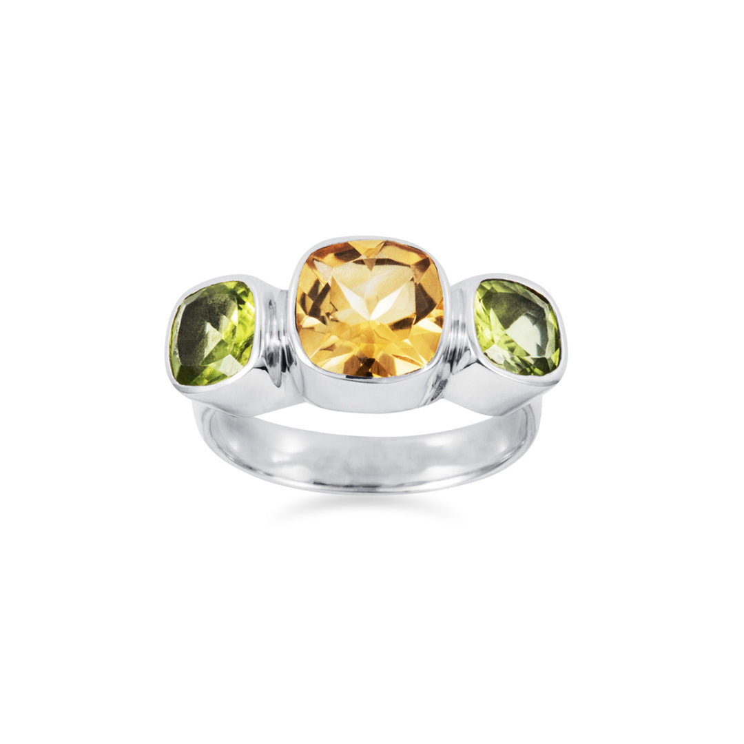Front view of square yellow and green gemstones set in a silver ring on a white background