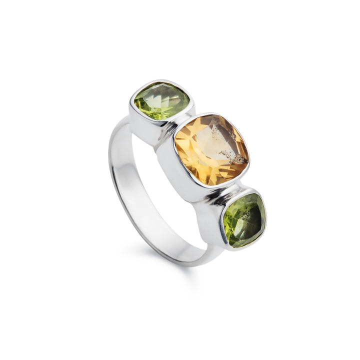 Silver three stone ring with citrine and peridot cushion-cut stones on a white background