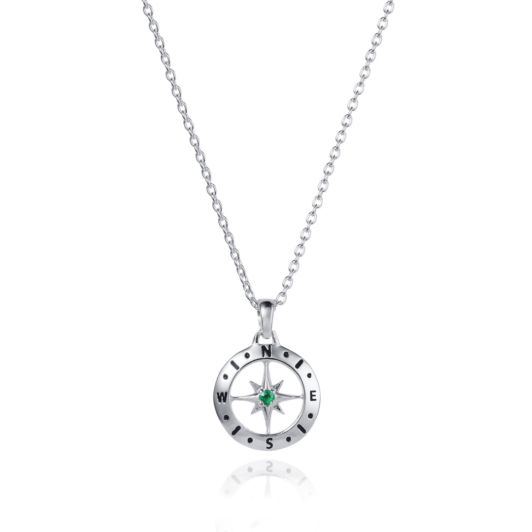 Dainty silver compass pendant with an emerald May birthstone on white background