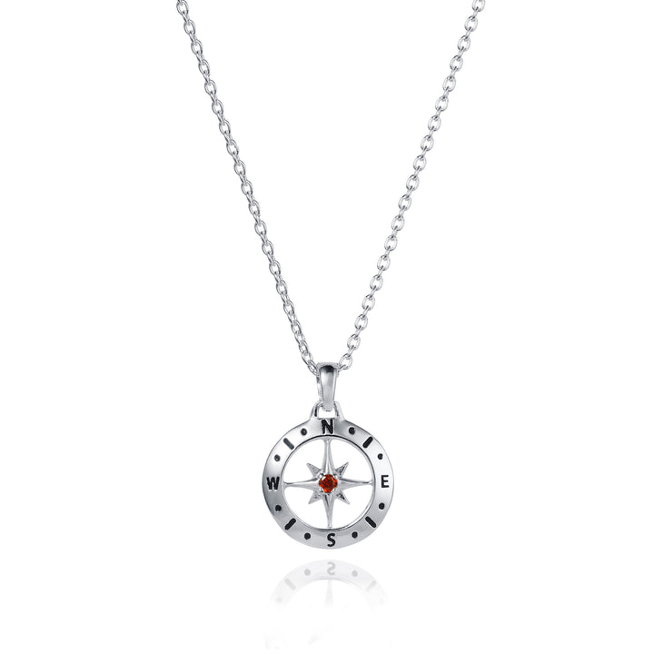 Dainty silver compass pendant with garnet january birthstone on white background