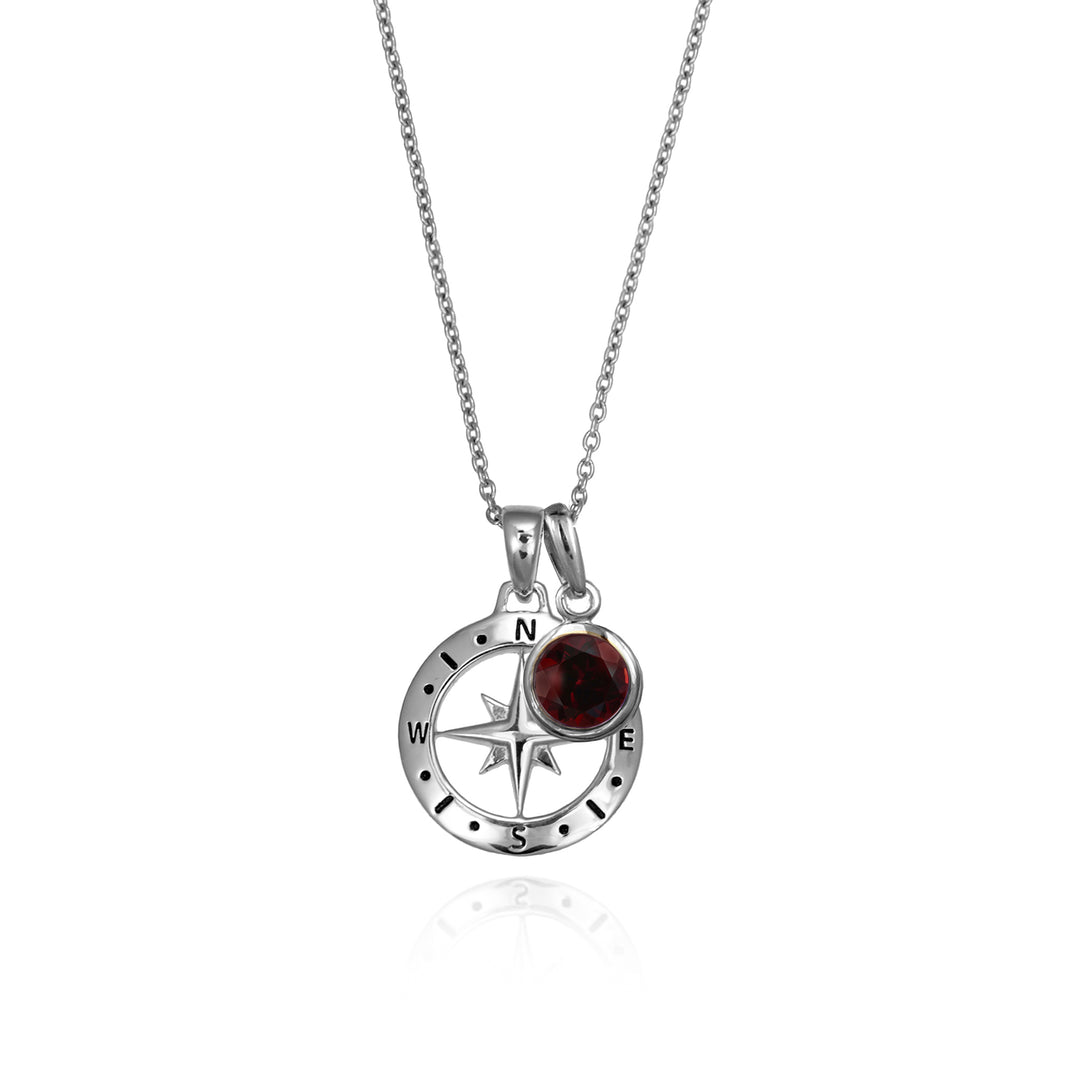 Silver compass necklace with an red garnet January birthstone charm pendant and chain on a white background