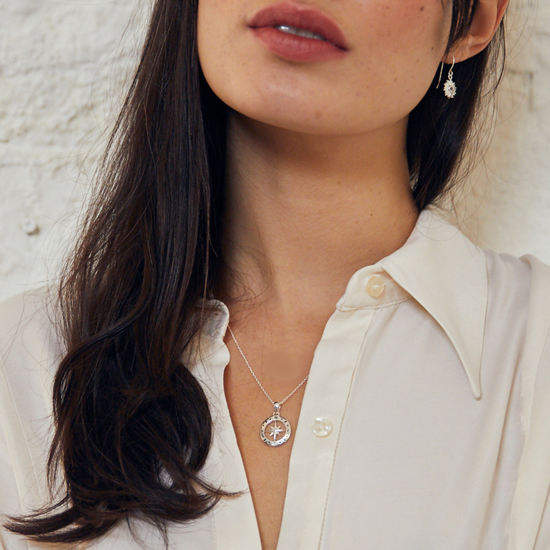 Model wearing a silver compass necklace