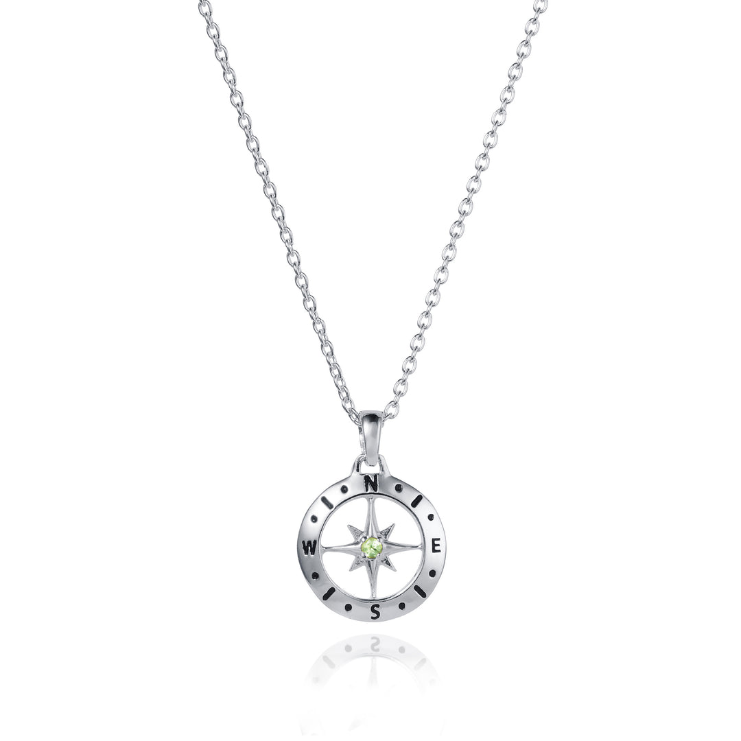 Dainty silver compass pendant with peridot August birthstone on white background