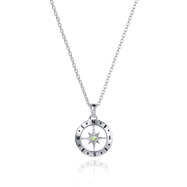 Dainty silver compass pendant with peridot August birthstone on white background