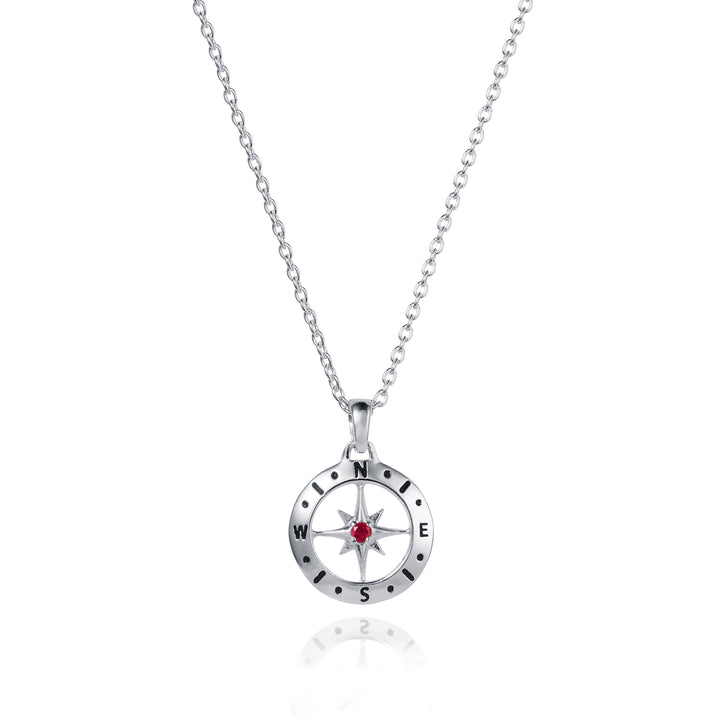 Dainty silver compass pendant with ruby July birthstone on white background