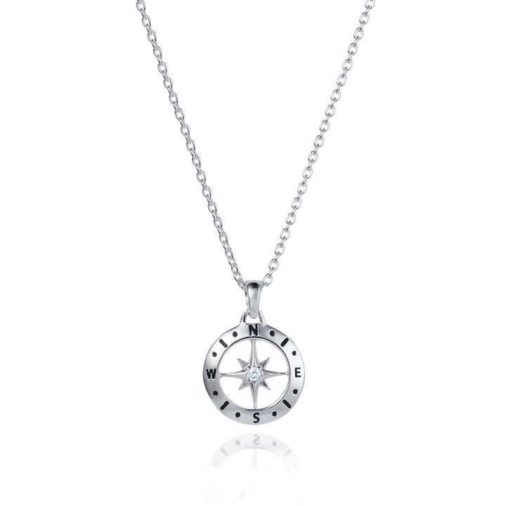 Dainty silver compass pendant with white topaz April birthstone on white background