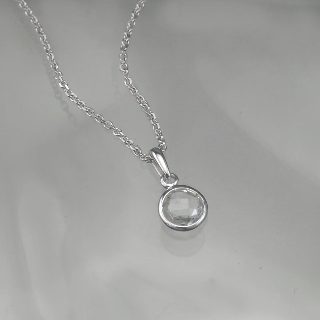 Silver white topaz necklace with a gray background 