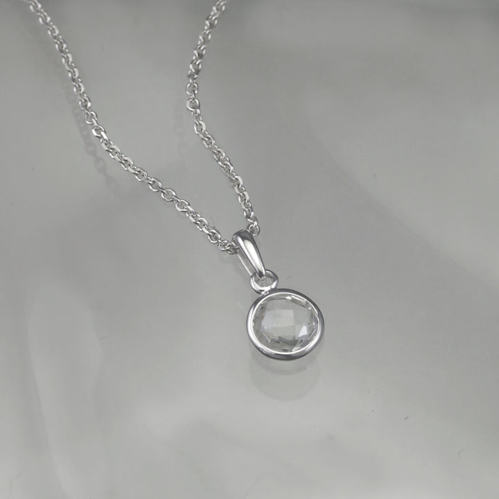 Silver white topaz necklace with a gray background 