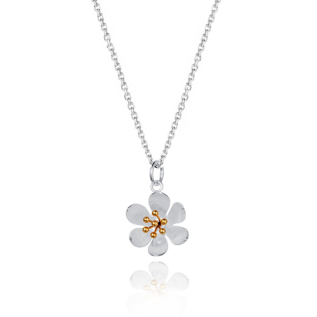 Silver daisy flower necklace with gold stamens on a white background