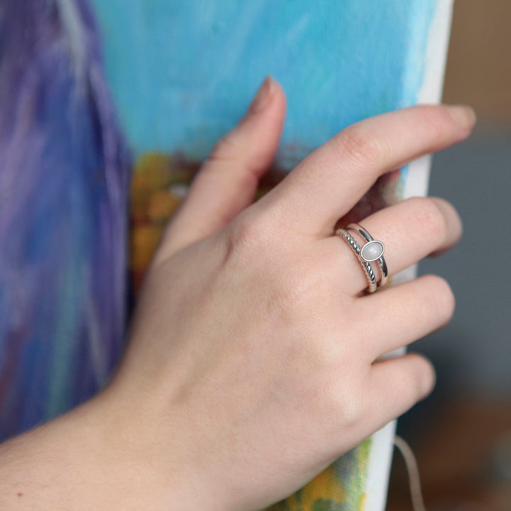 Model wearing a silver ring with a white moonstone