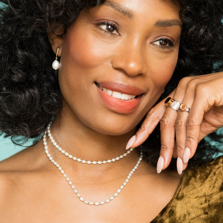 Woman wearing a silver and pearl necklace and choker set 