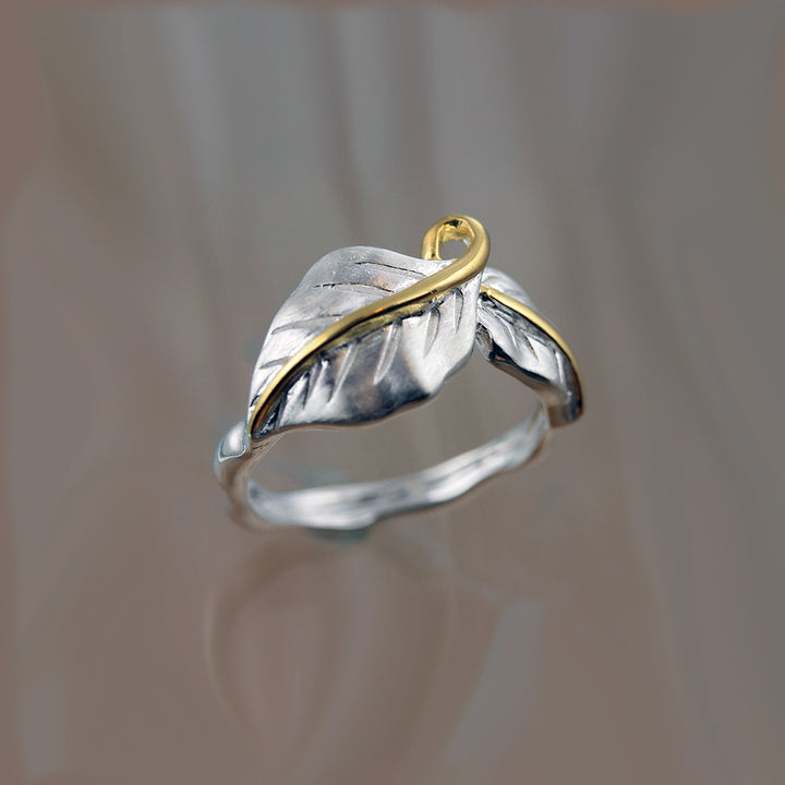 Silver double leaf ring with gold vermeil stems on reflective surface