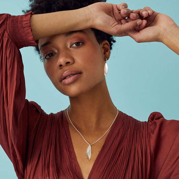 Handcrafted textured silver necklace displayed on model