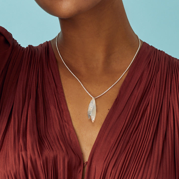 Close-up of hammered finish on curved silver pendants