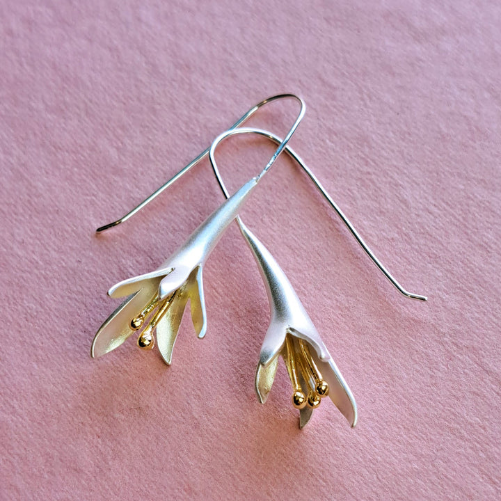 Sterling silver fuchsia flower drop earrings – alternative view on pink background