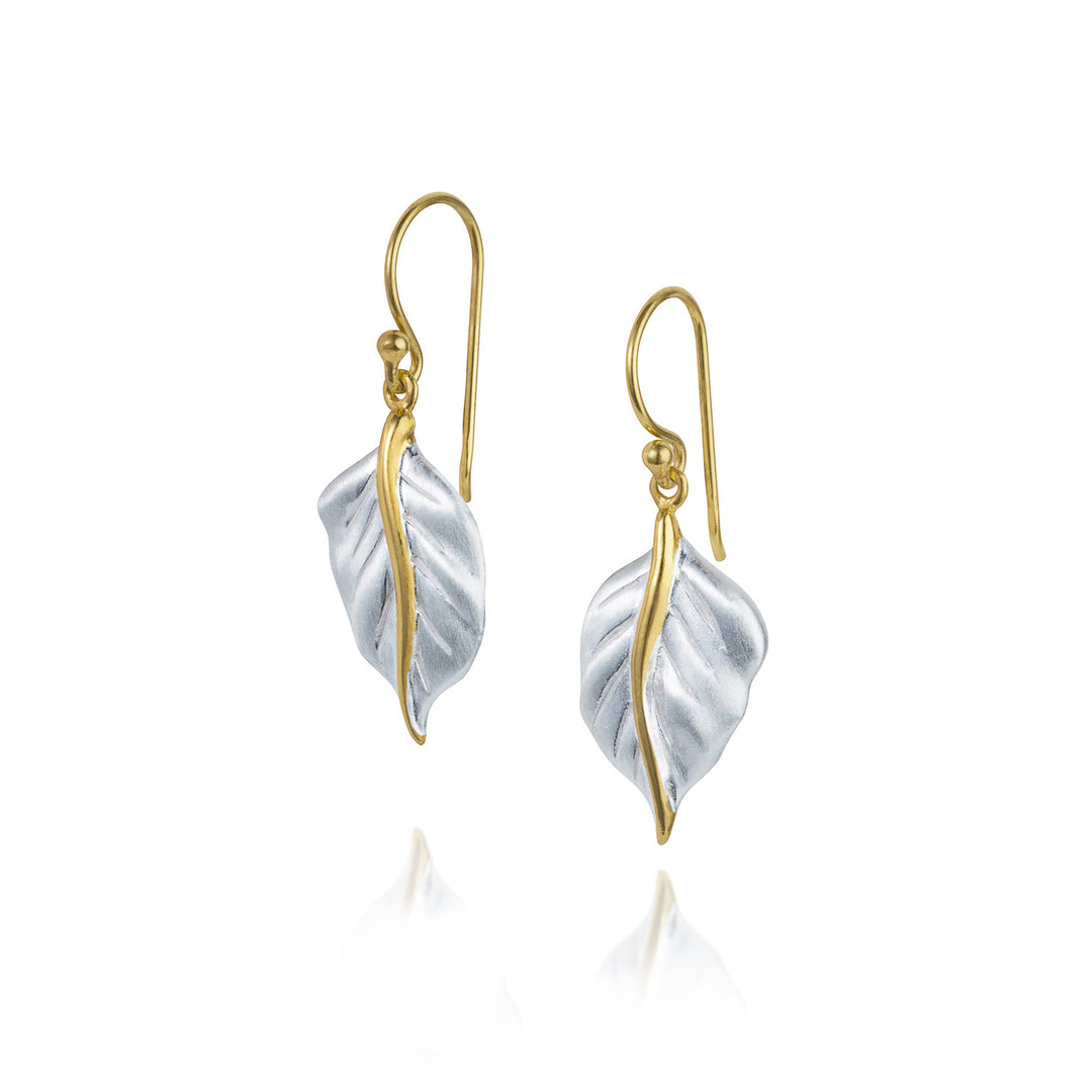 Pair of gold and silver leaf-shaped earrings on a white background