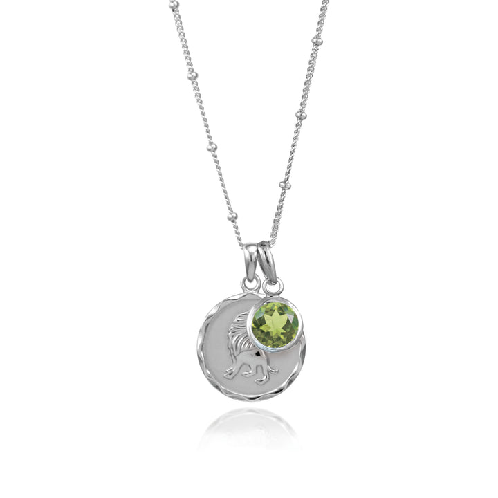 Silver Leo zodiac pendant and peridot August birthstone charm on gray background
