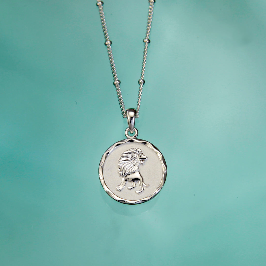 SIlver Leo zodiac pendant on an aqua background