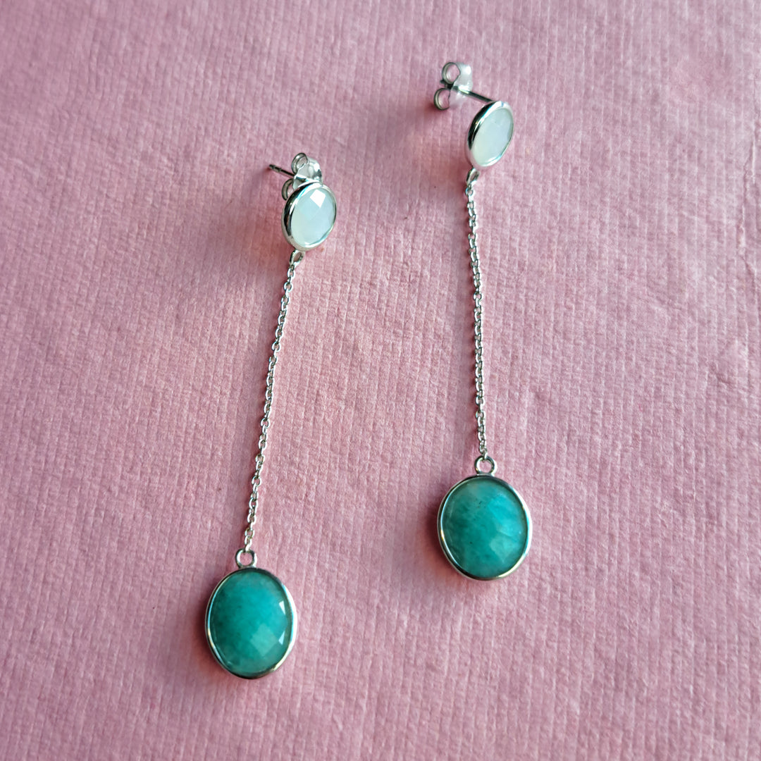 Sterling silver long drop earrings with amazonite and moonstone gemstones on a pink background