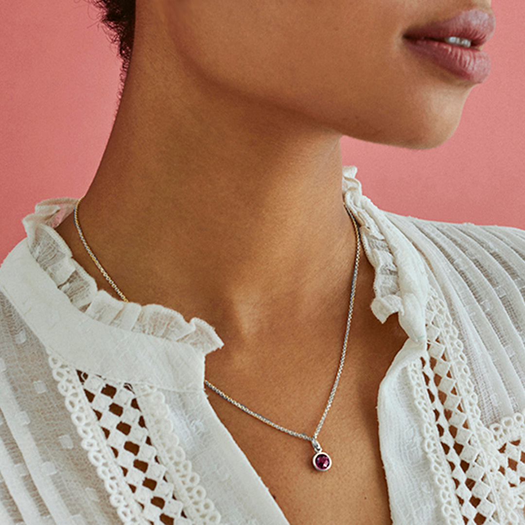 Model wearing silver garnet pendant with chain