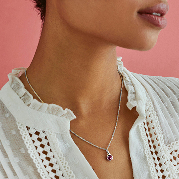 Model wearing silver garnet pendant with chain
