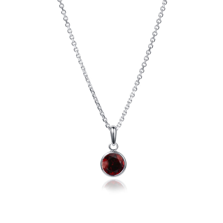 Small round garnet pendant necklace in sterling silver on a white background