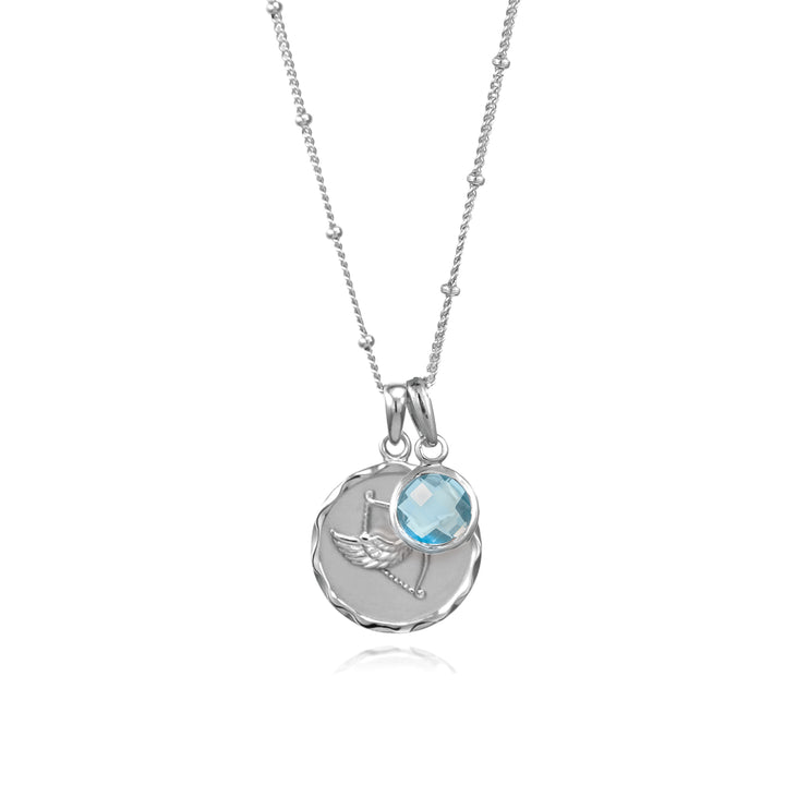 Silver sagittarius zodiac pendant and blue topaz December birthstone charm on a gray background