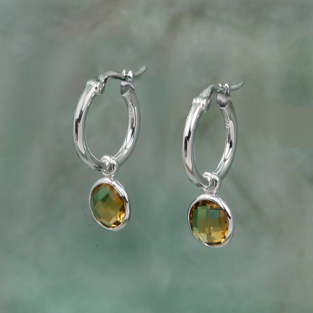 silver snap-post hoop earrings with golden brown gemstone drops on a gray background