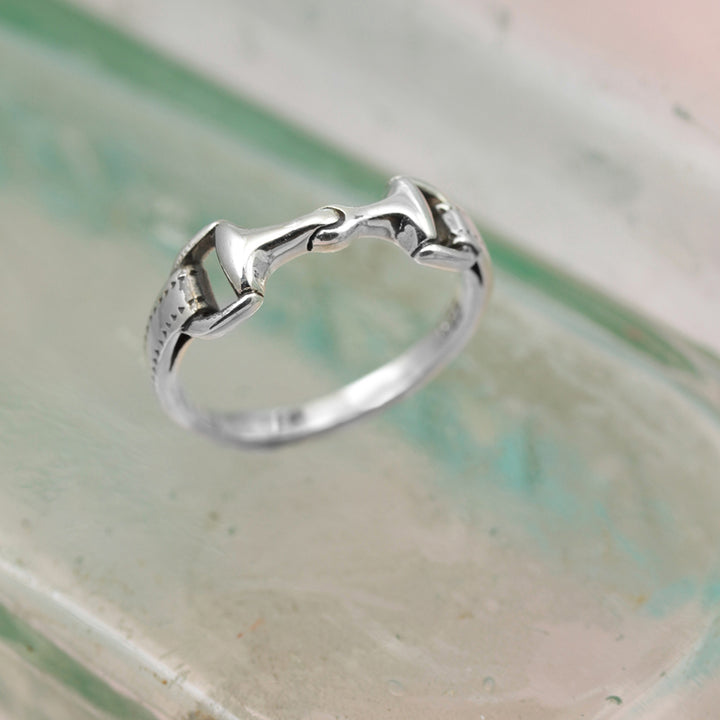 Sterling silver horse bit ring on reflective surface