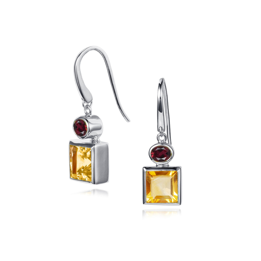 Pair of silver earrings with square-cut citrine and oval garnet gemstones on a white background