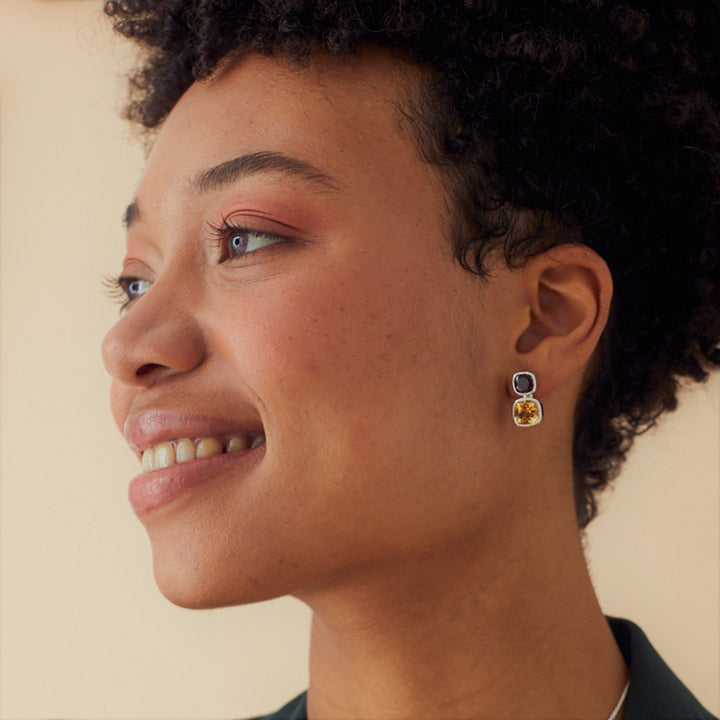 Model wearing silver stud earrings with citrine and garnet