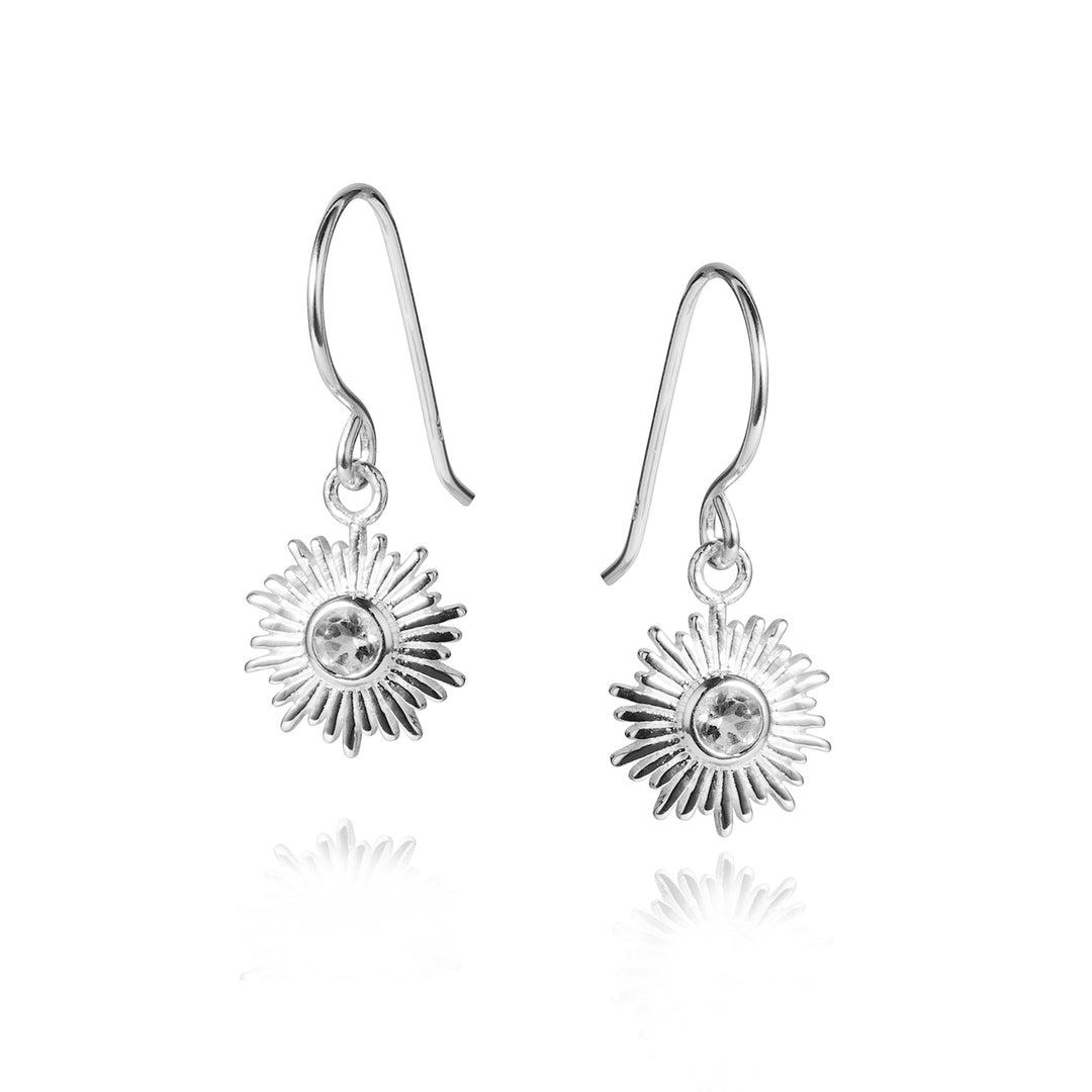 Silver drop earrings with sun charms set with white topaz on a white background