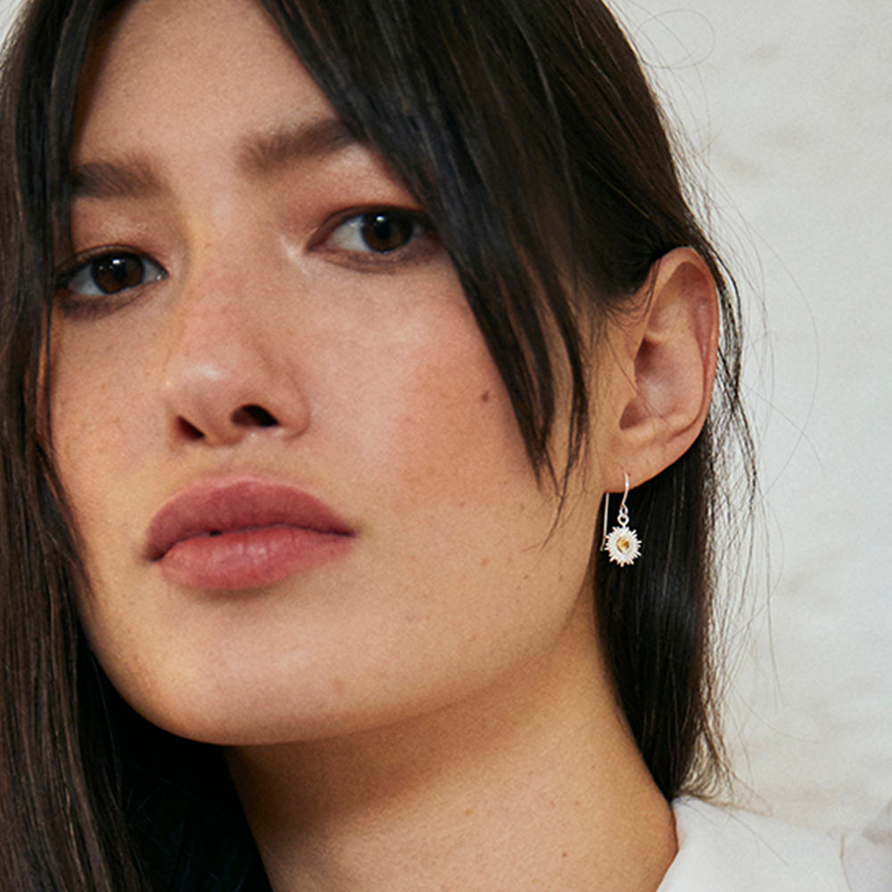 Close-up of model wearing silver sun drop earrings with citrine 