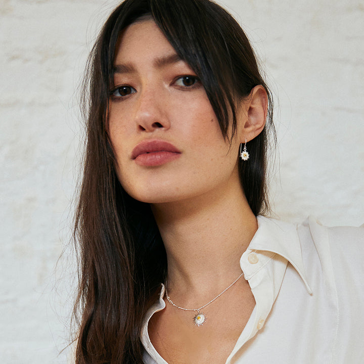 Model wearing a silver sun earring and necklace set featuring yellow citrine gemstones.