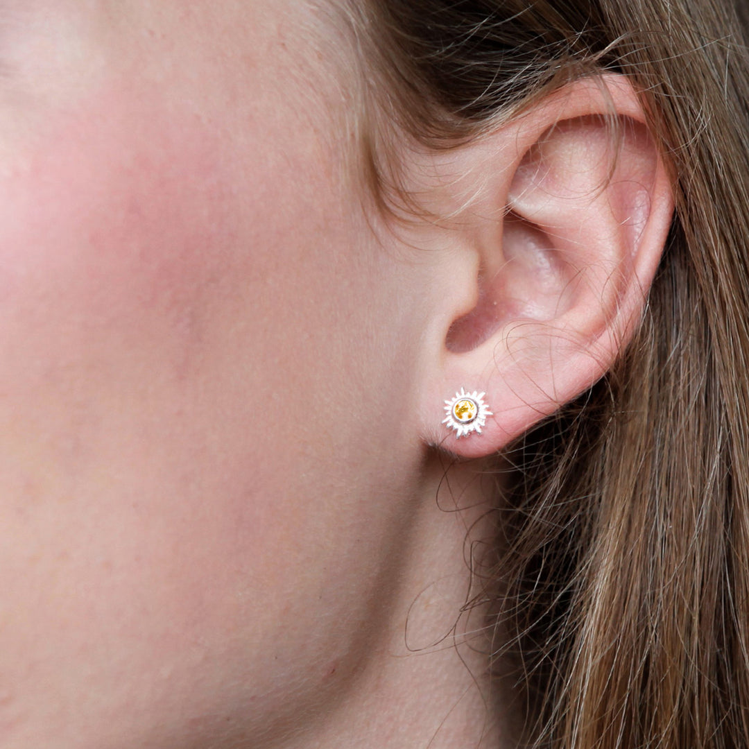 Close-up of silver sun post earrings featuring honey coloured citrine gemstones