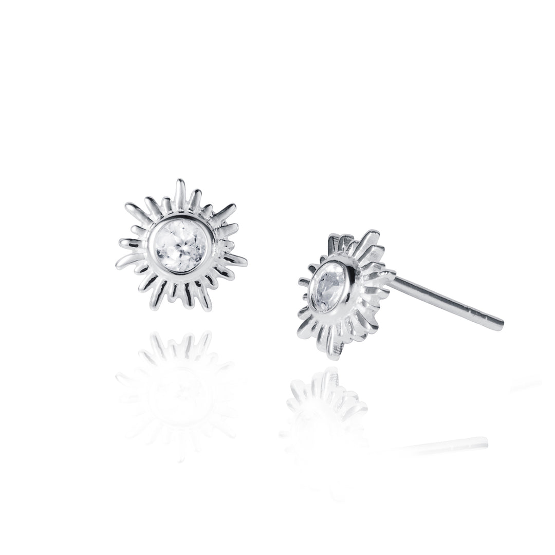 Silver sun stud earrings with white topaz gemstones on a white background