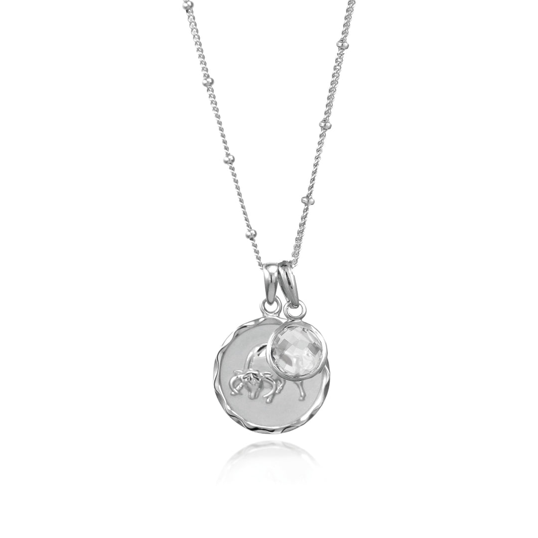 Silver Taurus Zodiac Pendant with a white topaz April birthstone charm on a white background