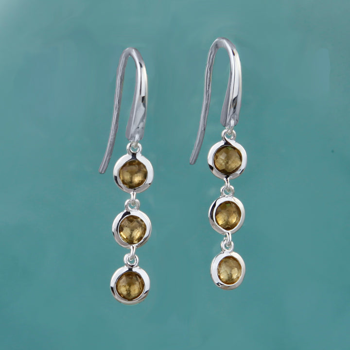 silver and smoky quartz triple drop earrings on an aqua background