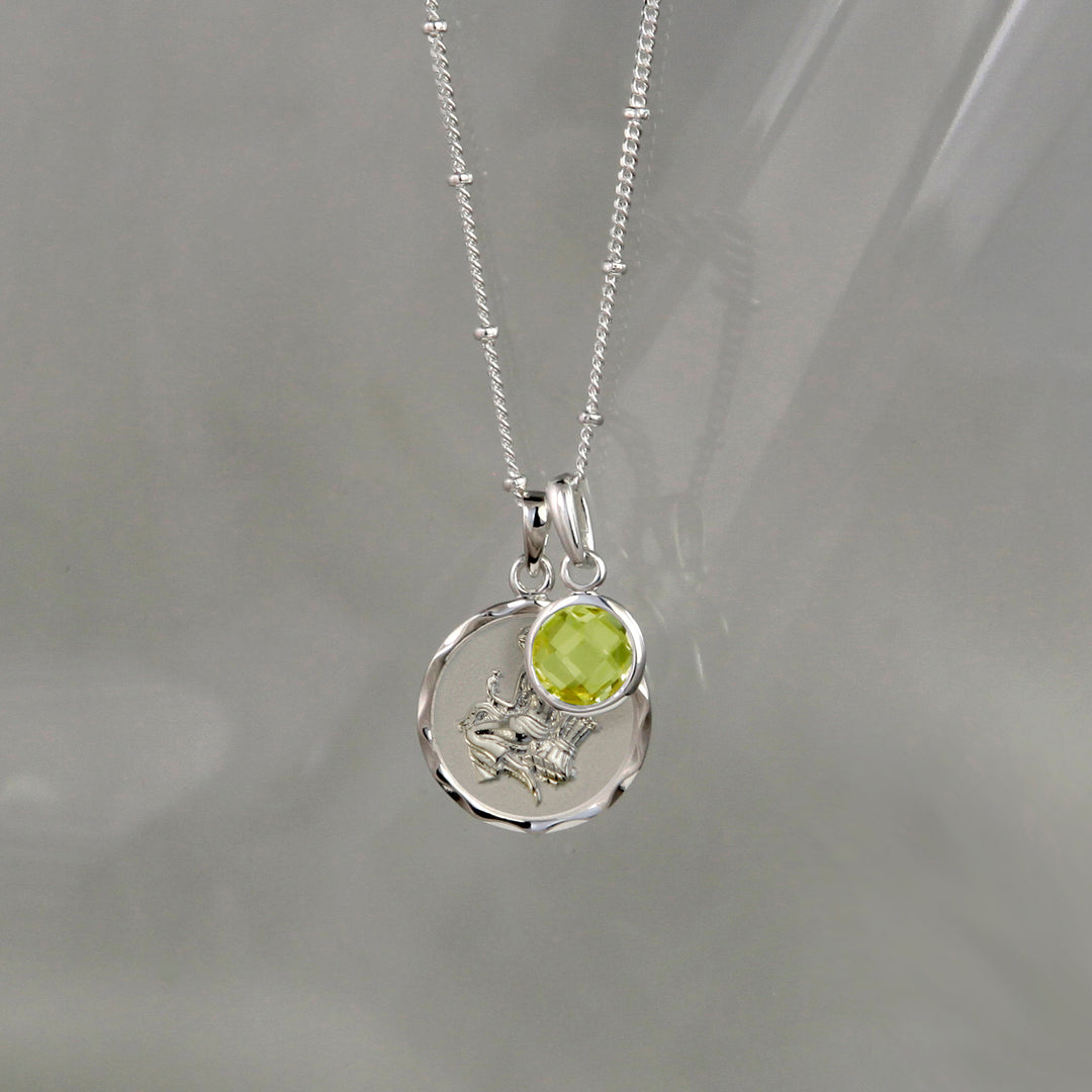 Silver virgo star sign pendant with green peridot August birthstone charm on gray background