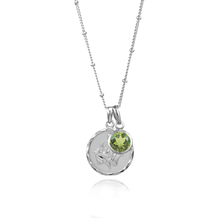 Silver virgo star sign pendant with green peridot August birthstone charm on white background