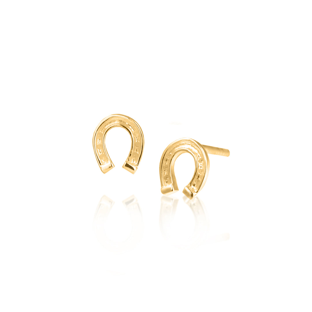 Gold horseshoe stud earrings on a white background