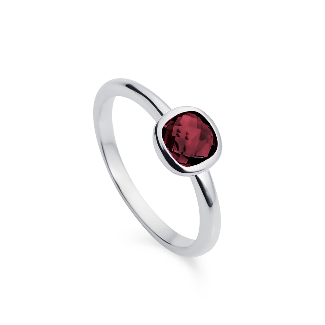 Silver ring with a square red gemstone on a white background