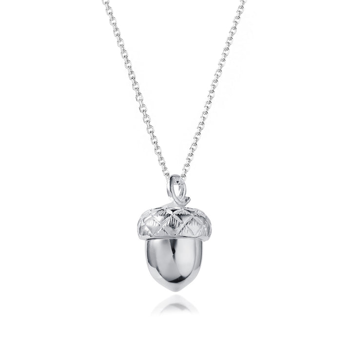 Closed silver acorn locket necklace on white background.
