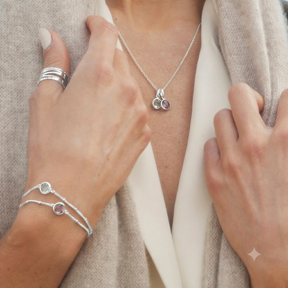 Close-up of woman wearing sterling silver beaded chain bracelet with blue topaz with matching necklaces