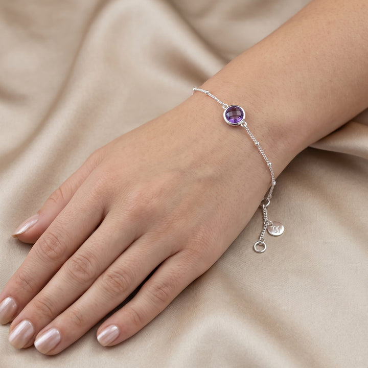Woman wearing a sterling silver beaded chain bracelet with amethyst