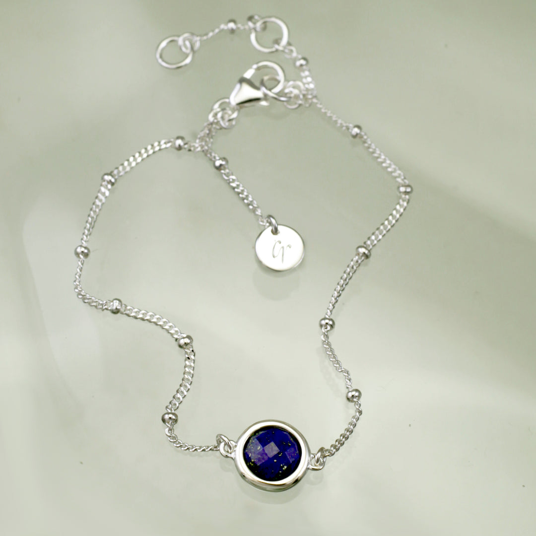 Sterling silver beaded chain bracelet with lapis lazuli on a reflective background